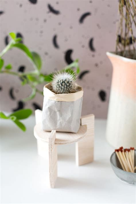 A Small Potted Plant Sitting On Top Of A Wooden Stand