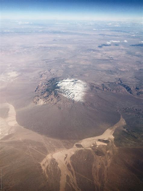 View Of Desert From High Above The Clouds In An Airplane By Stocksy