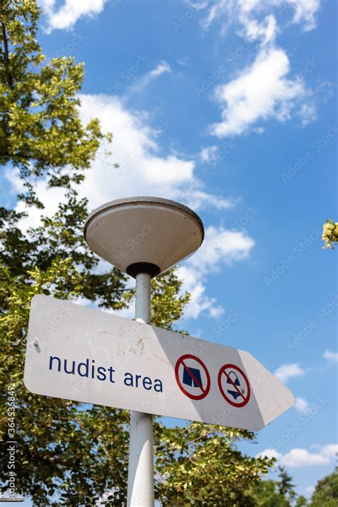 Foto Stock Information Sign Indicating Designated Area For Nude Sunbathing Nudist Area