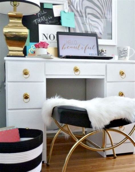A White Desk Topped With A Black And White Chair Next To A Gold Framed