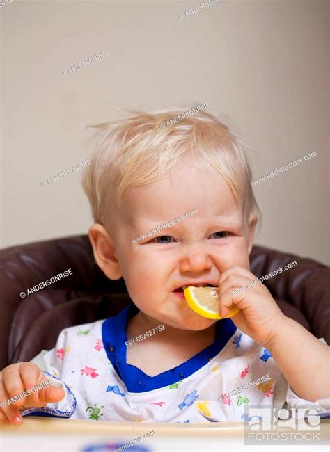 Portrait Of Blonde Baby Boy Sitting At The Dinner Table Stock Photo