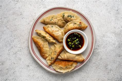 A Plate Filled With Dumplings And Dipping Sauce