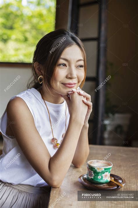 Smiling Japanese Woman Sitting At Table In Japanese Restaurant — Mid Adult Woman One Person