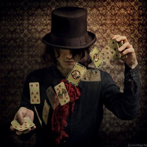 A Man Wearing A Top Hat And Holding Playing Cards In One Hand With Both