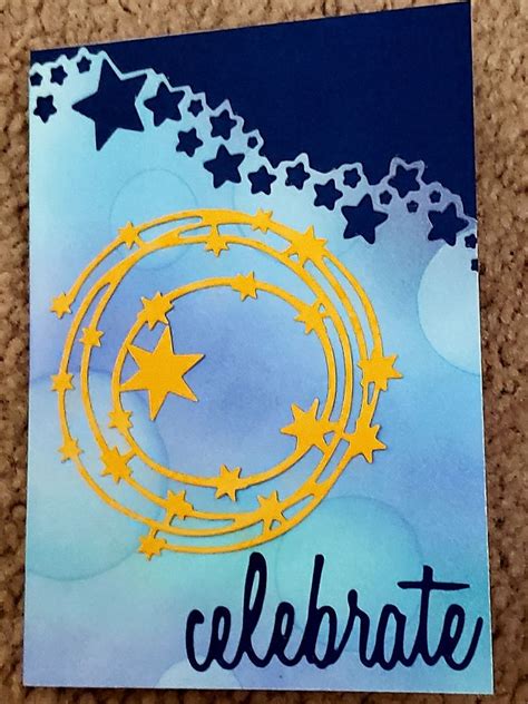 A Handmade Card With Stars And The Word Celebrate Written In Blue