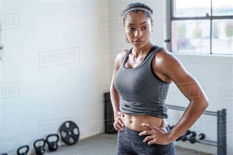 Female Athlete With Hands On Hip Looking Away While Standing In Gym Stock Photo Dissolve