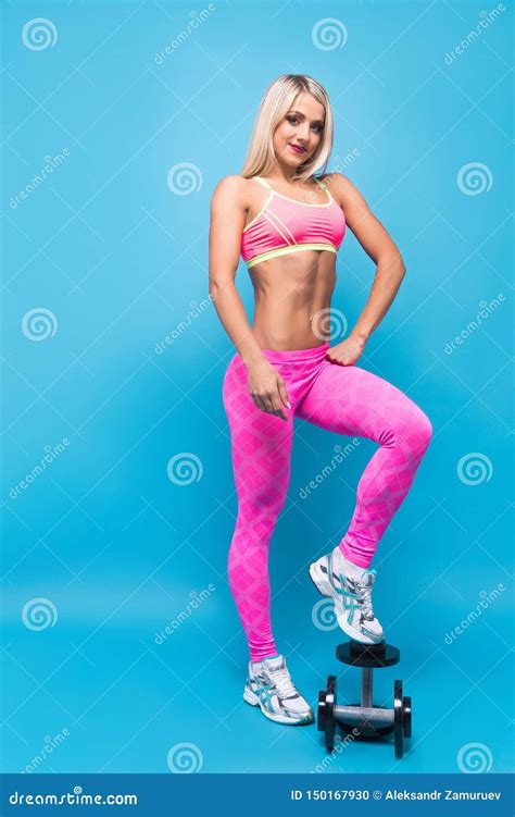 Portrait Of Attractive Blonde Woman In Pink Sportswear Posing With