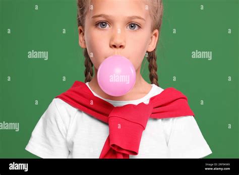 Girl Blowing Bubble Gum On Green Background Stock Photo Alamy
