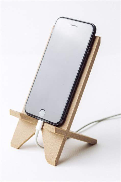 An Iphone On A Wooden Stand With A Charger Plugged Into The Charging