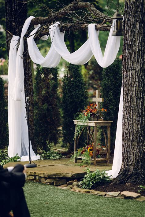 White Draping Over Tree Branches At An Outdoor Wedding With A Fall Floral Altar For A Outdoor