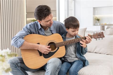 Padre Enseña A Su Hijo A Tocar La Guitarra Foto Premium