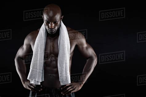 Portrait Of African Male Athlete After Workout Against Black Background