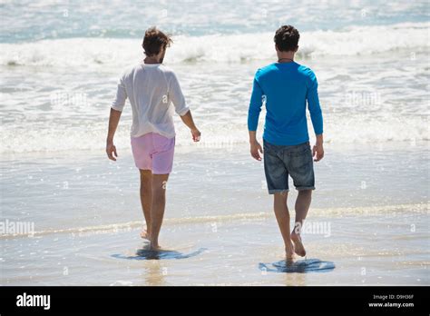 Two Men Walking On The Beach Stock Photo Alamy