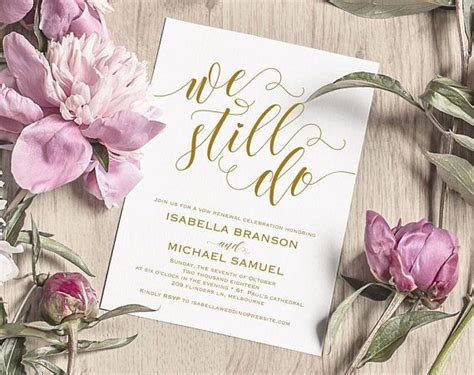 The Wedding Card Is Surrounded By Flowers And Greenery On A Wooden