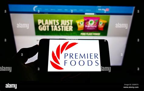 Person Holding Smartphone With Logo Of British Food Manufacturer