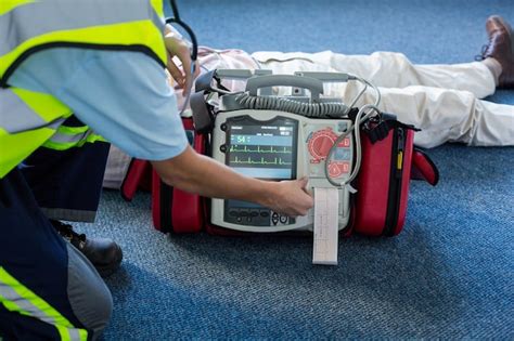 Premium Photo Paramedic Using An External Defibrillator During