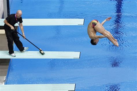 Good Form A Worker Cleaned A Diving Board As An Athlete Trained At The