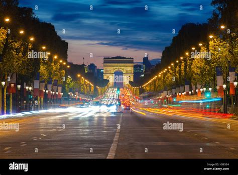 Night View Of Paris Traffic In Champs Elysees Street And The Arc De