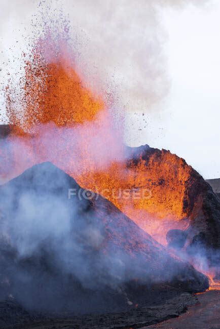 Splashes Of Hot Orange Lava Erupting From Volcanic Mountain Peak