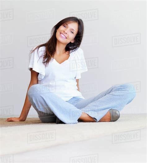 Woman sitting cross legged on floor - Stock Photo - Dissolve