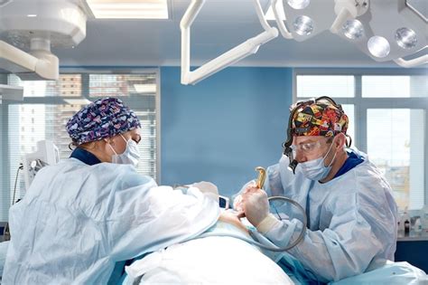 Premium Photo A Surgeon With An Assistant Operates On The Female