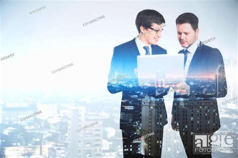 Businessmen Using Laptop Together On Abstract City Background Stock