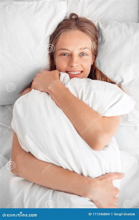 Morning At Home Woman Lying On Bed Hugging Pillow Smiling Relaxed Top