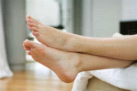 Womans Bare Feet Legs Crossed At Ankle Stock Photo Dissolve