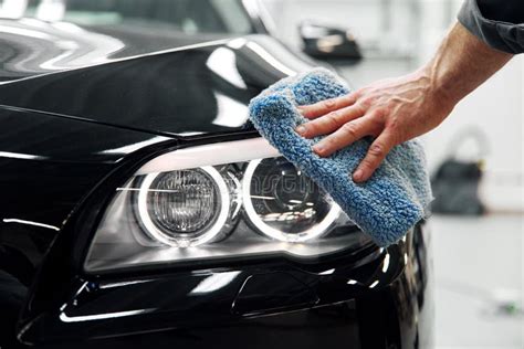 Car Detailing The Man Holds The Microfiber In Hand And Polishes The