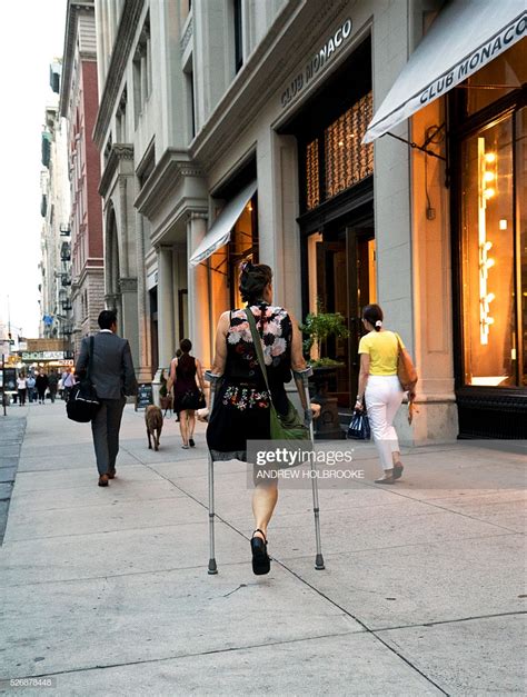 Woman With An Amputated Leg Walks With The Aid Of Crutches