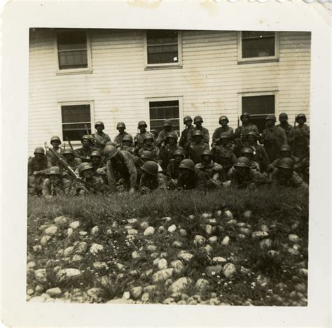 Group Of Us Soldiers In Full Combat Gear Stand In Front Of Barracks