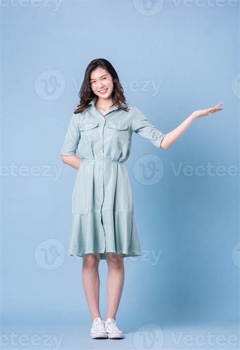 Full Length Image Of Young Asian Woman Wearing Dress On Blue Background