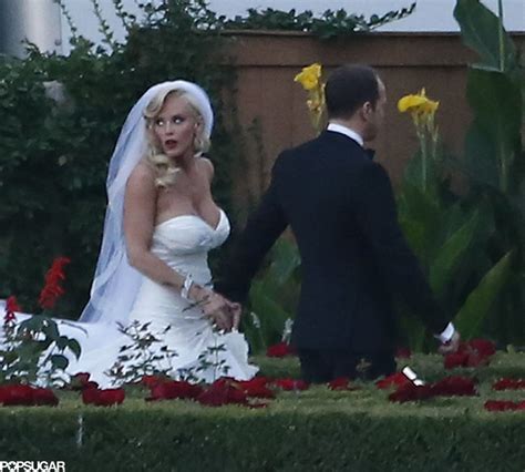 The Bride And Groom Are Walking Through Their Garden