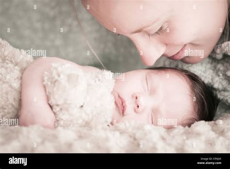 Mother Leans Over Newborn Baby To Kiss Stock Photo Alamy