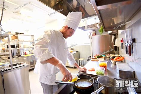 Happy Male Chef Cooking Food At Restaurant Kitchen Stock Photo