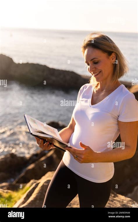 A Woman Reading A Naturist Book By The Sea At Sunset Healthy And