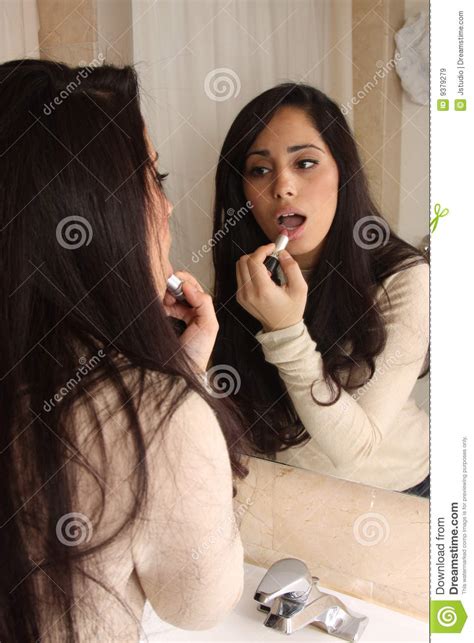 Female Putting On Lipstick Royalty Free Stock Images