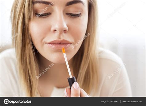 Portrait of happy young woman applying lipstick — Stock ...