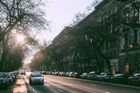 Wide Straight Road With Parked Cars In Cityscape On Sunny Morning