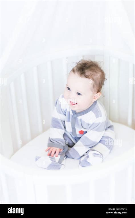 Sweet Baby Girl Sitting In A Round White Bassinet Stock Photo Alamy