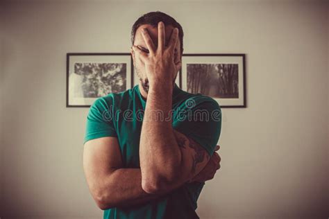 Photograph Of A Man With His Hand In Front Of His Face Stock Photo
