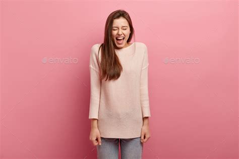 Emotions And Feelings Concept Overjoyed Pleasant Looking Young Woman Laughs Loudly Has Fun In