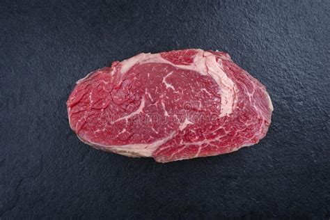 Raw Dry Aged Wagyu Rib Eye Beef Steaks On A Black Board Stock Photo