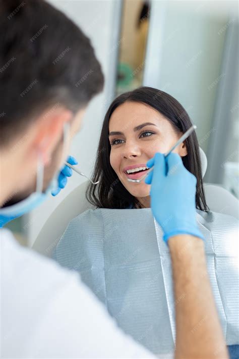Premium Photo Female Smiling Client At Dental Procedure Dentist Using