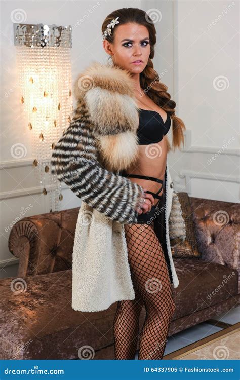 sensual glamour woman wearing elegant black lingerie sexy tights and luxury fur coat stock