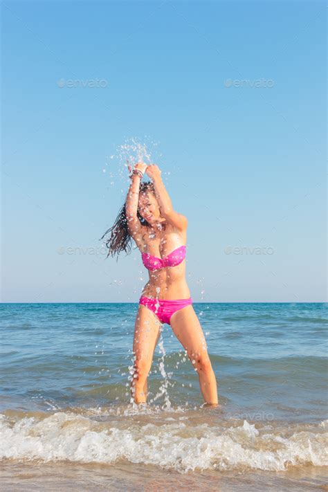 Babe Woman In Bikini On The Beach Splashing Water Stock Photo By Netfalls