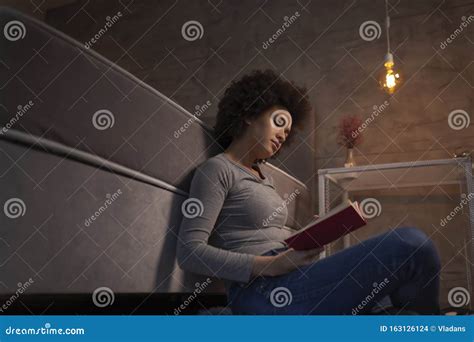 Woman Sitting Next To Bed And Reading A Book Stock Photo Image Of