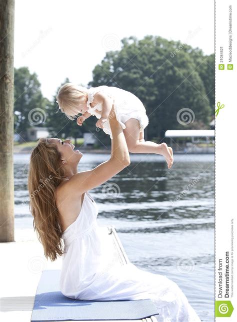 A Mother Holds Her Daughter Playfully In The Air Stock Image Image Of