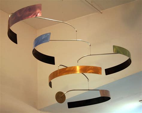 A Group Of Metal Objects Hanging From The Ceiling In A Room With White