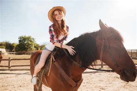 Happy Pretty Young Woman Cowgirl Riding Horse On Ranch Royalty Free